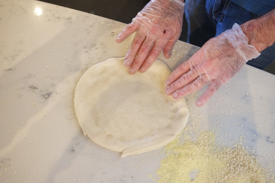 Pâte à pizza étalée à la main sur un plan de travail